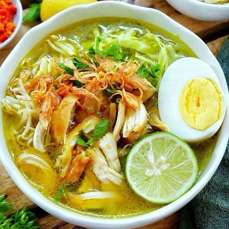 a picture of soto ayam, a turmeric-yellow semi-clear indonesian chicken soup dish!