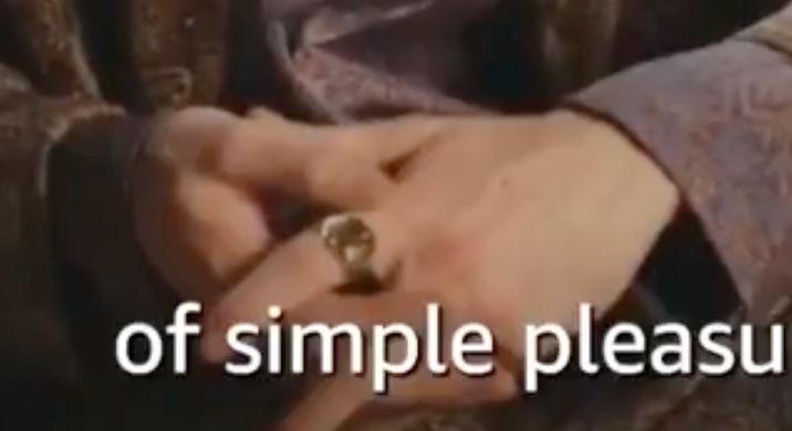 A close up screenshot of Mat from a Wheel of Time interview. It shows his hands with a gold ring on his left pointer finger.