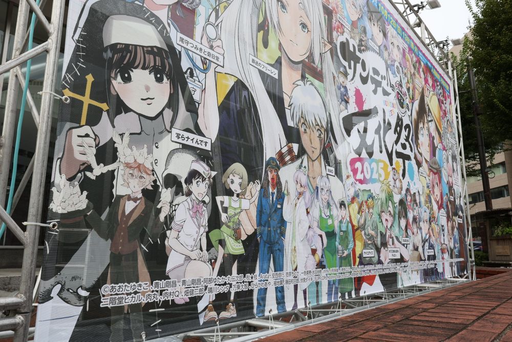 サンデー文化祭の集合イラストの看板を斜めから撮った写真、前列にイッコちゃん