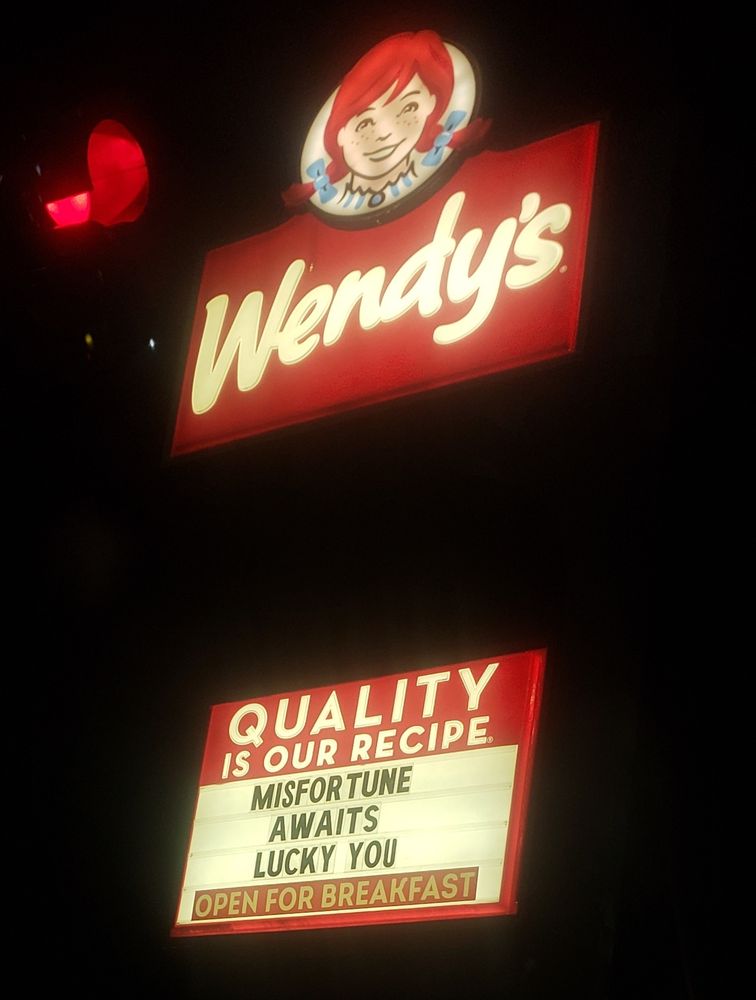 a Wendy's sign that says "Misfortune awaits, lucky you" 