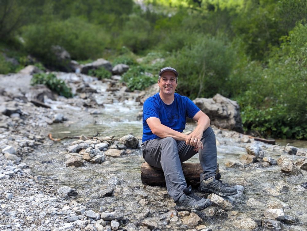 Me sitting on a log in the middle of a small stream.