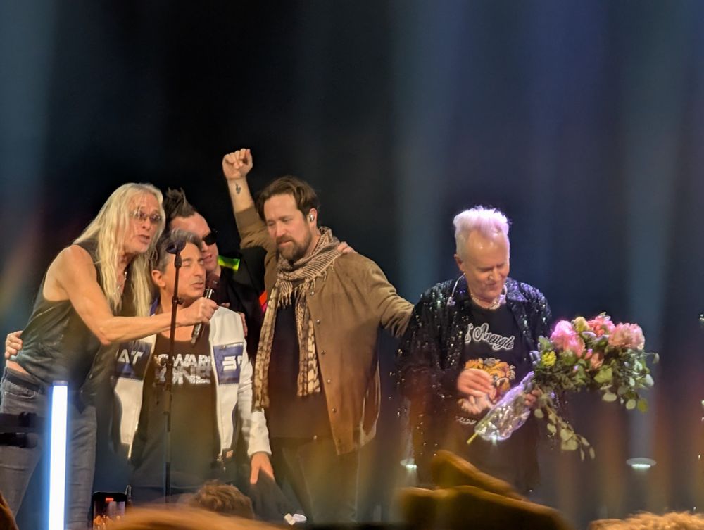 Photo of Howard Jones getting a birthday bouquet while his band and the audience serenade home after his set at the Warner Theater in Washington DC