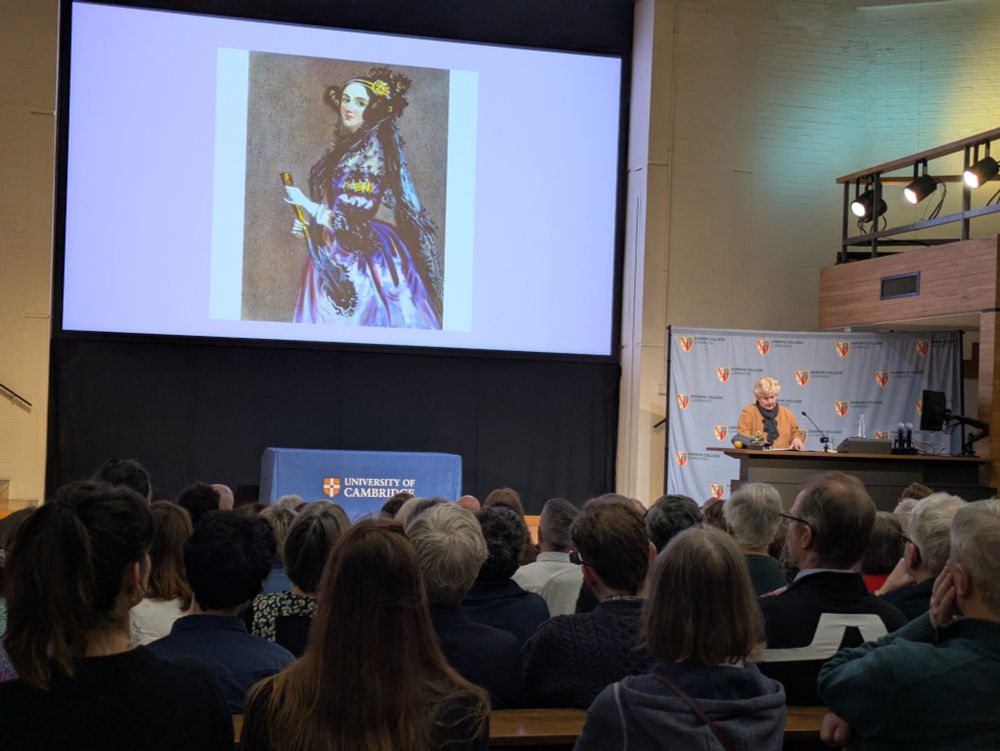 Sandi at a podium presenting a picture of Ada Lovelace 