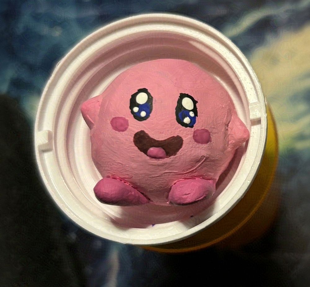 Image is of a polymer clay Kirby sitting in a medicine bottle cap.