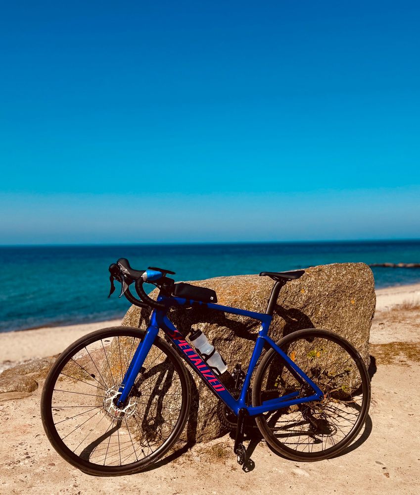 Rennrad am Stein im Hintergrund die Ostsee 
