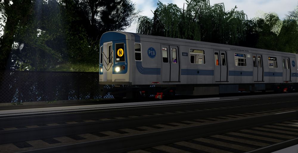 PST-2R on the N line with the Heritage Livery with trees in the backgroubd