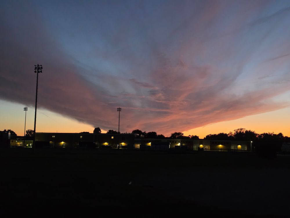 Big ass Cloud Rising over a building at sunset
