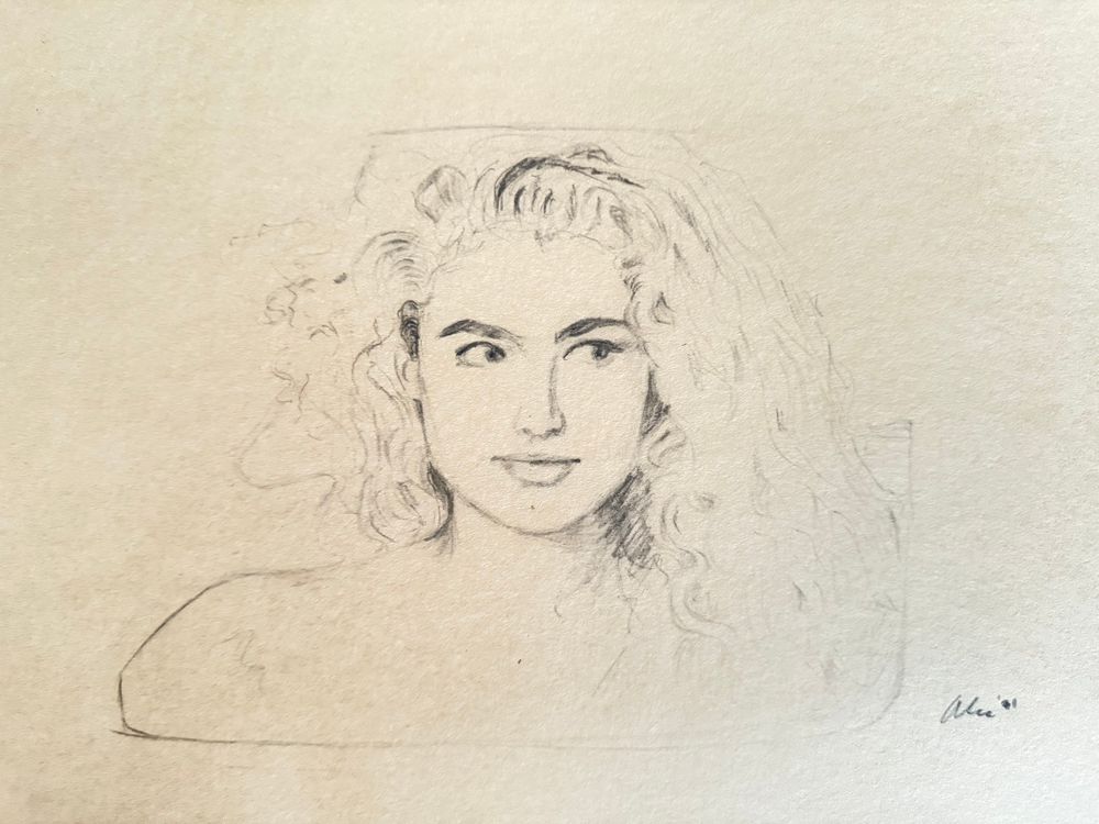 Photo of a drawing I did of supermodel Elaine Irwin from the New Order video, “Round & round.” It’s pencil on manila colored paper. She has a half smile and is looking to her left. It’s signed by me (the artist), Alec ‘91. I’m huge into recycling and using all materials around me: even when I was 21 years old! So, back then I took a bunch of stray manila papers, cut, tore, and stapled them together. What you see here is the first page. This was done during my downtime in 1991. It was something to do. I never continued with the project, so I have a bunch of paper left to draw whatever I want on them. Digital technology is great but whatever artwork we do on computers, phones, tablets, etc. will not last. All digital files will eventually be lost forever as technology moves on to the next phase. That’s why I draw everything I do for myself on paper first. Those drawings I do on paper will last and be around for future generations to look back and wonder what life was like in, let’s say, the year 1991.