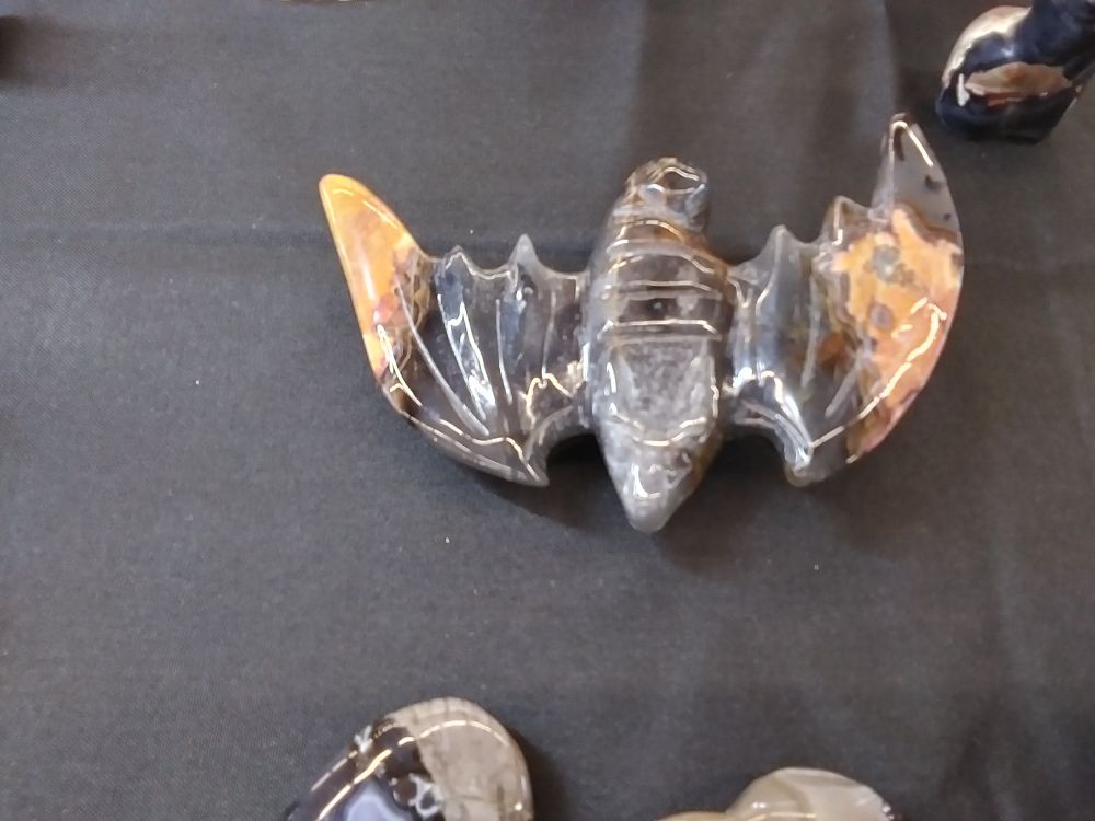 Carved black and brown stone that is shaped like a bat 