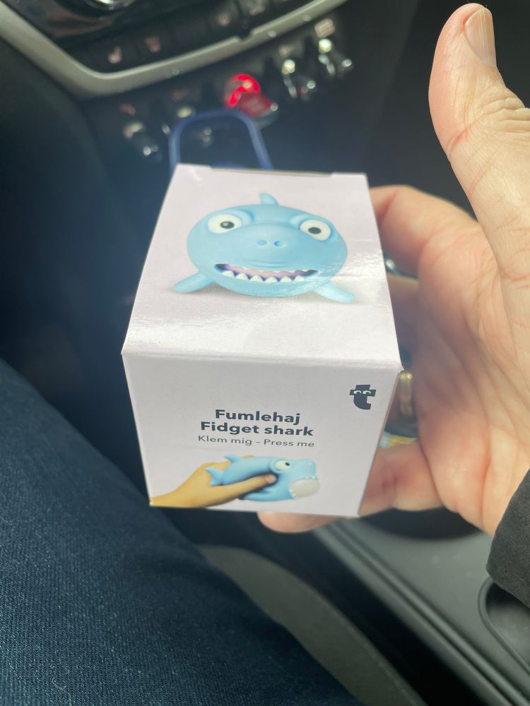 Perla hält eine kleine Schachtel in der Hand. Darin befindet sich ein kugeliger Knautsch-Hai, der bei Stress hilft…