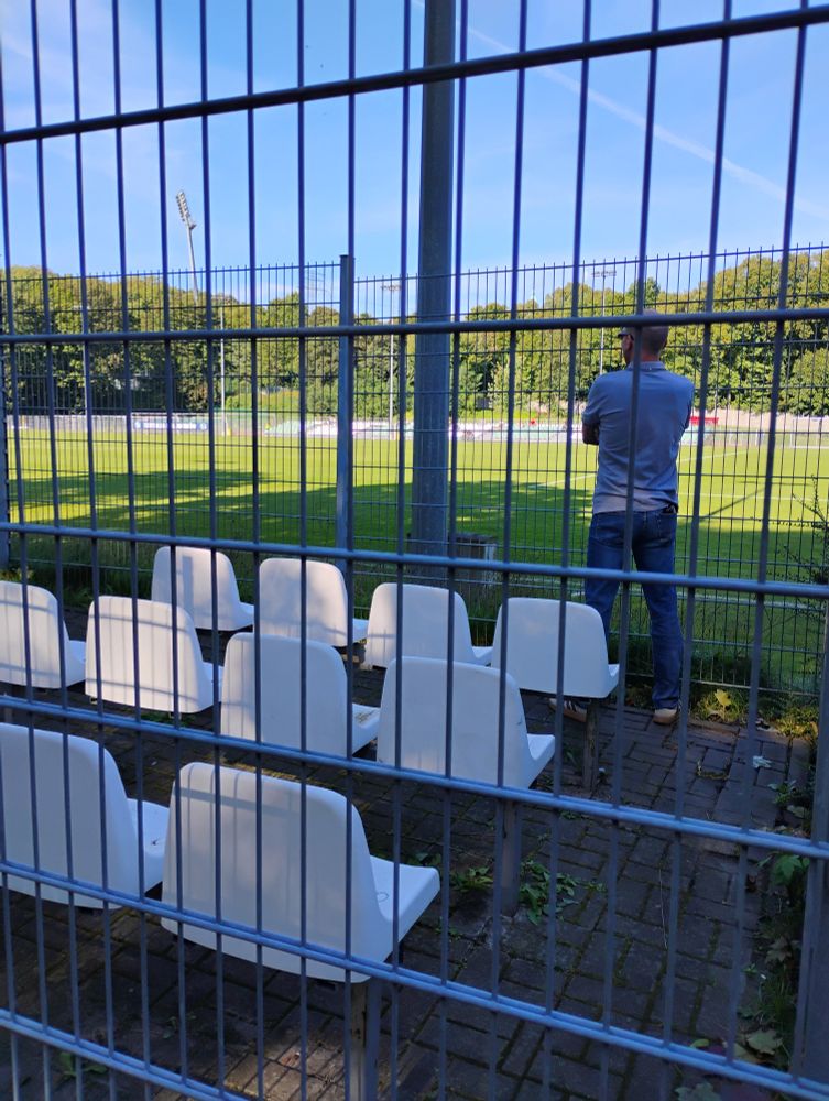 Ein Fußball Fan steht alleine im Gäste Käfig 