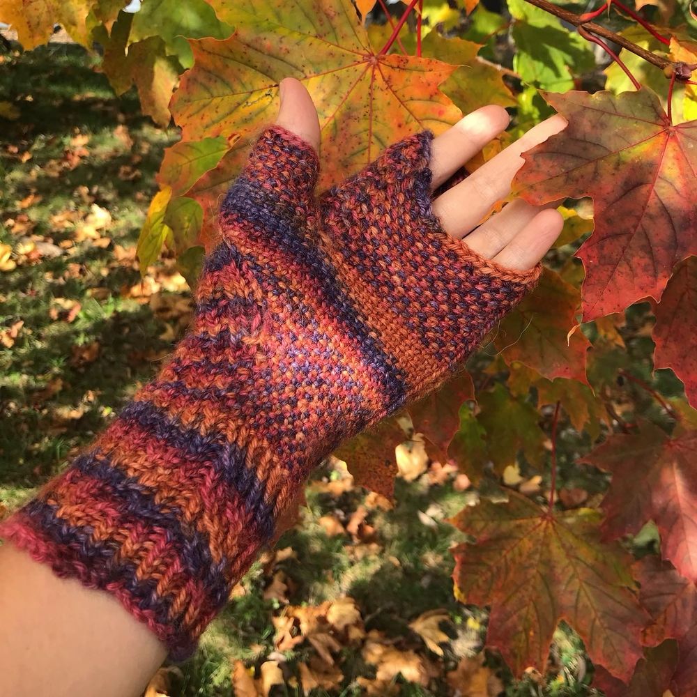 Palm of "Atomic Robin Hood Marion Mitt" with background of fall leaves. 