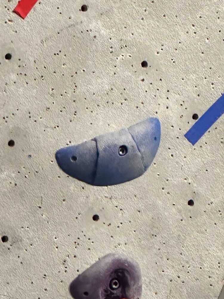 blue plastic rock climbing hold in the shape of a croissant