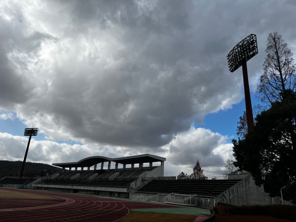 陸上競技場と大きな雲