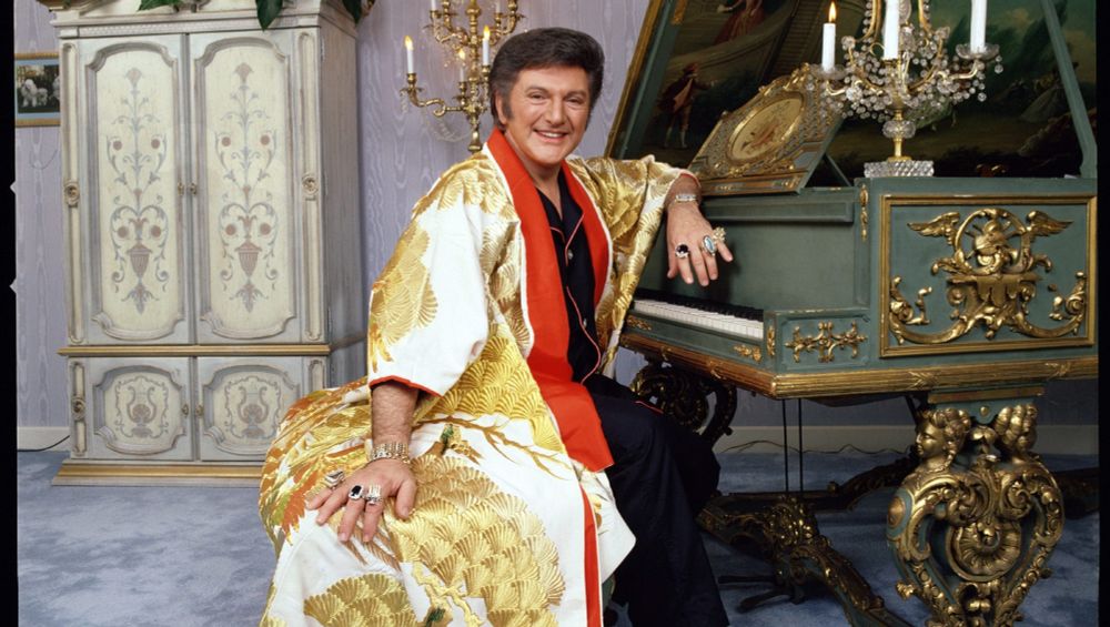 Liberace seated at a piano