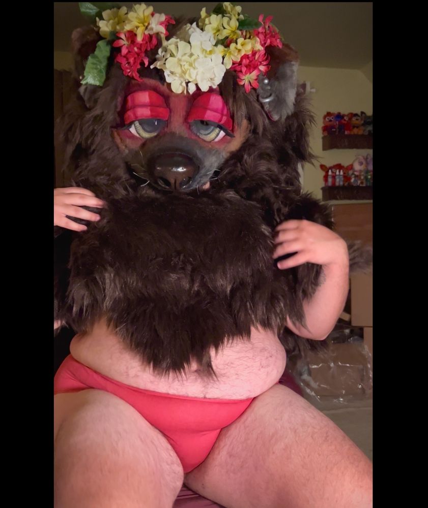 Bailey (mask and fur poncho) with her hands on her shoulders and her thighs slightly apart to show off her hot pink panties that match her flower crown. 