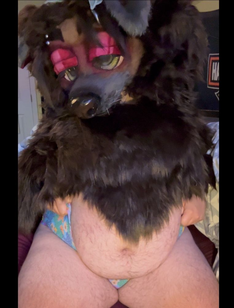 Bailey sitting on the bed, pulling up the sides of her teal panties so her tummy protrudes in a nice round ball. Shes looking slightly down to the left
