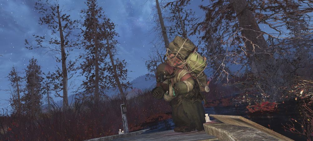 A mole miner in heavy gear stands on a wooden platform in a dark, forested area under a starry sky in Fallout 76.