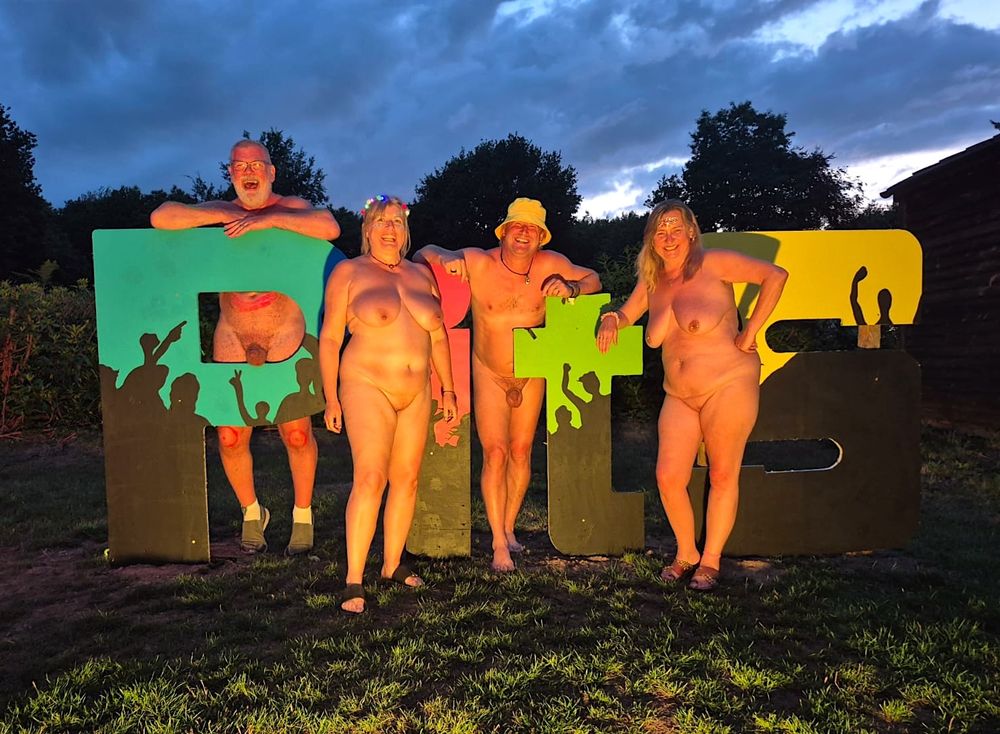 Four people stood by a festval sign that reads "PitS"