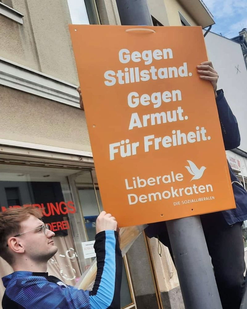 Oranges Wahlplakat mit weißem Text "Gegen Stillstand. Gegen Armut. Für Freiheit."
Unten ist das Logo der Liberalen Demokraten.