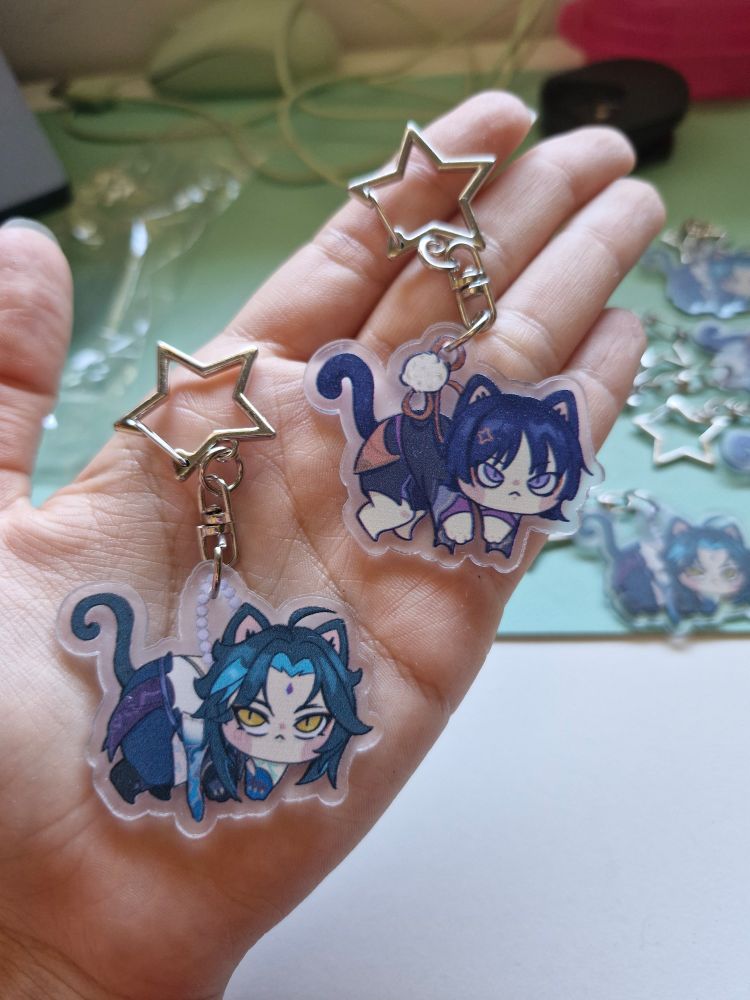 foto de uma mão segurando os chaveiros da imagem anterior