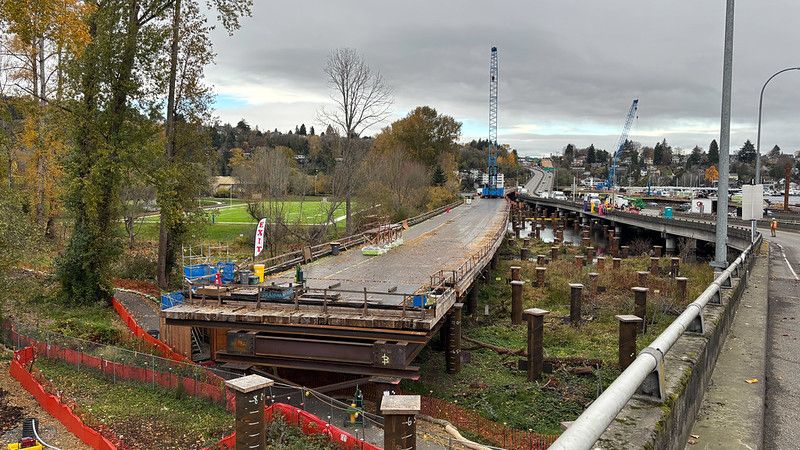 A visual guide to a few of the ramps and bridges on Portage Bay.
View looking west at Seattle's Portage Bay. 

Left: This is a temporary work bridge being used to build the new SR 520 Portage Bay Bridges.

 

Center: Those pipes in the ground and the water will support a temporary eastbound SR 520 off-ramp to Montlake Boulevard.

Right: This is the existing off-ramp. After we shift traffic onto the temporary off-ramp in 2026, crews will demolish this one.