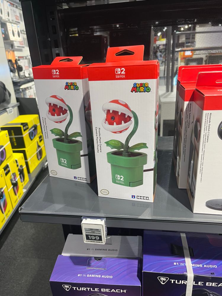 Boxes on a store shelf, depicting a webcam for the Nintendo Switch 2, shaped like a piranha plant from the Super Mario franchise 