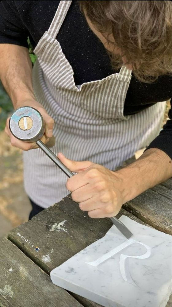 Me again, carving lettering on reclaimed stones in our community garden in Bonnington Square, when I was living from London.