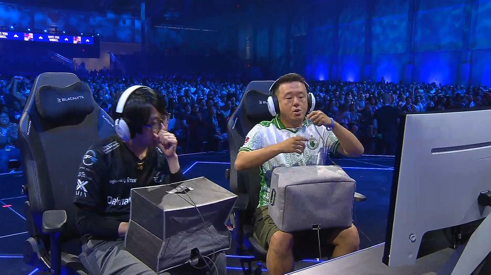 players GO1 and ET with cloth boxes on their laps to hide their hands while playing