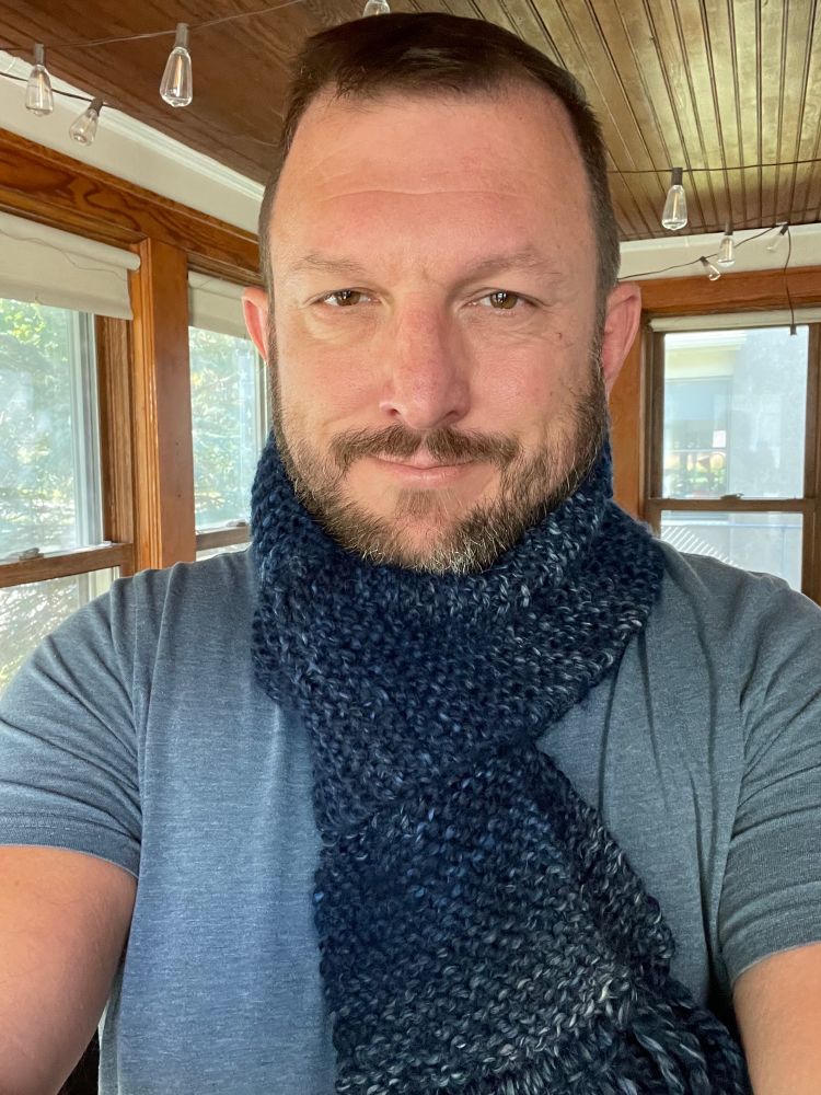 Bearded man wearing a blue knit scarf