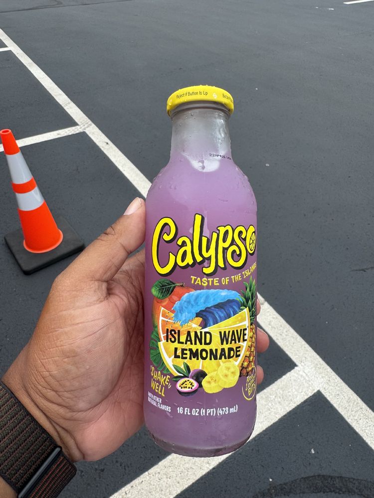 Human hand holding a bottle of Calypso Island Wave Lemonade.

The drink is purple, which adds to the mystique.