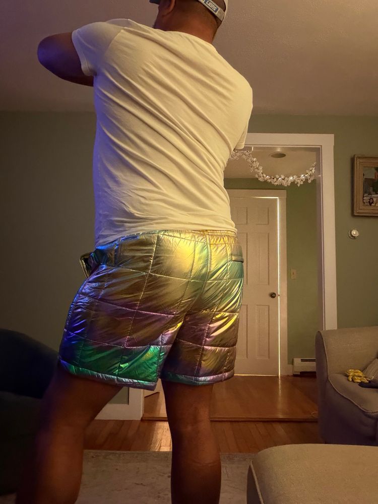 Rear view of me wearing a white tee and holographic puffy shorts