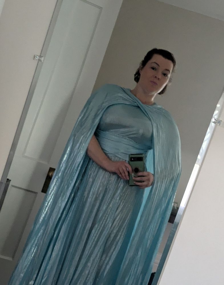 Taking a photo of myself in the full length mirror. I'm wearing a blue dress with long cape. I'm obviously feeling cute.