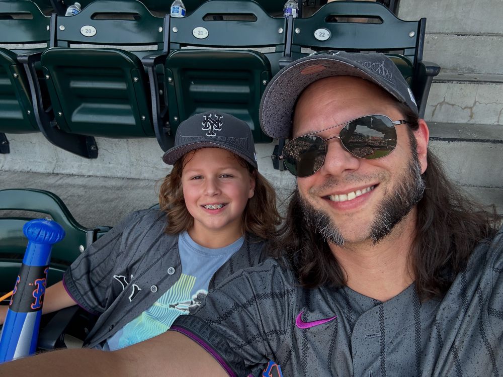 Father and son at a Met game. Both with great hair.