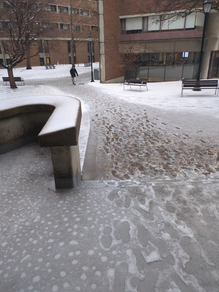 Stairs and a path between buildings covered in slippery wet snow.
