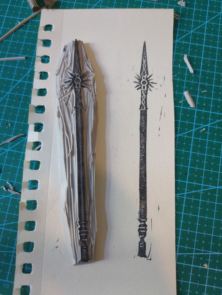 Baldur's gate 3 Night Spear lino cut print next to the lino cut stamp
