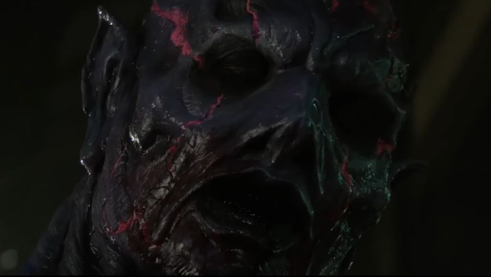 Psycho Goreman admiring a magazine full of hunky boys, who he does not care for... or does he?