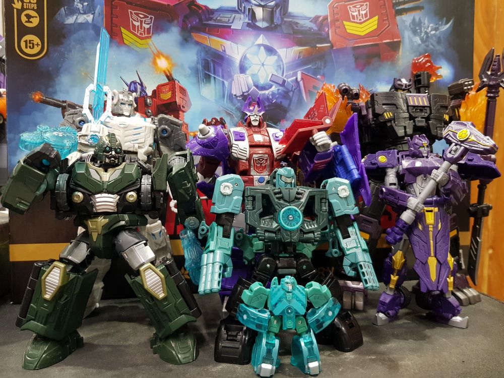 Images of various members of the 13 aprimes from the Transformers Age of the Primes toyline. From left to right: 

- McAdams
- Prima Prime
- Alpha Trion
- Micronus Prime
- The Fallen
- Solus Prime
- Star Optimus at the back 