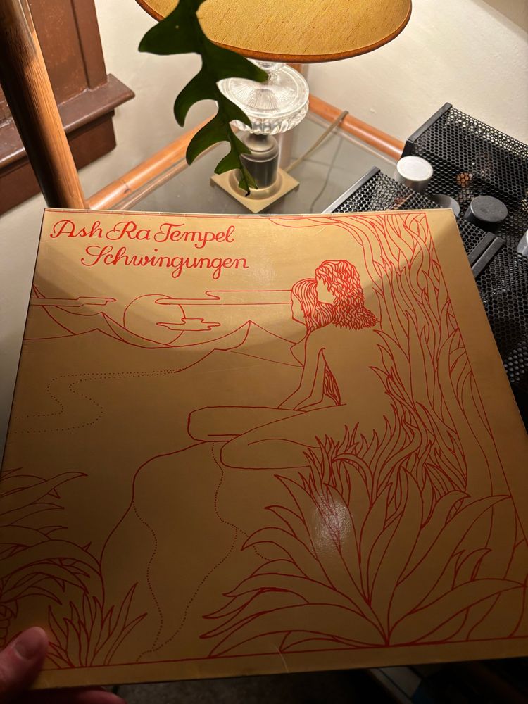 Picture of Ash Ra Temple “Schwingungen” album featuring a red line drawing of two figures watching the sunset on a beige background 