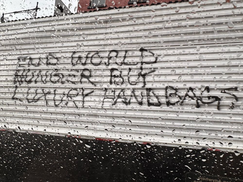 Graffiti: “End world hunger, buy luxury handbags”.