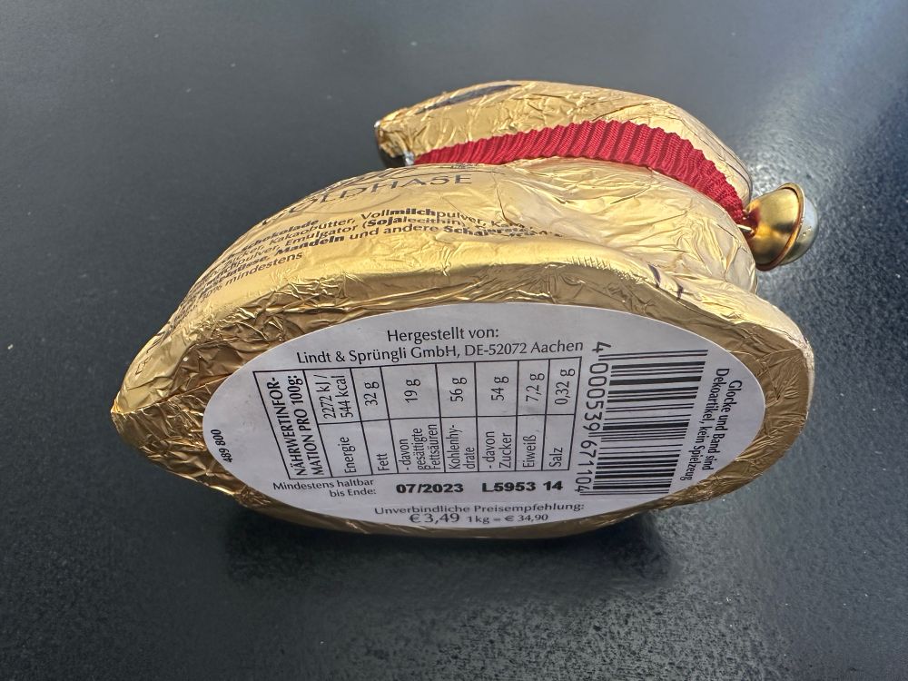 Ein auf der Seite liegender Lindt-Schokohase, man sieht auf der Unterseite, dass das MHD 7/2023 war