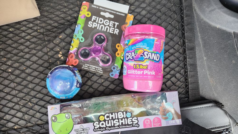 A Five Below haul of sensory toys including squishy toys, fidget spinner, and kinetic sand.