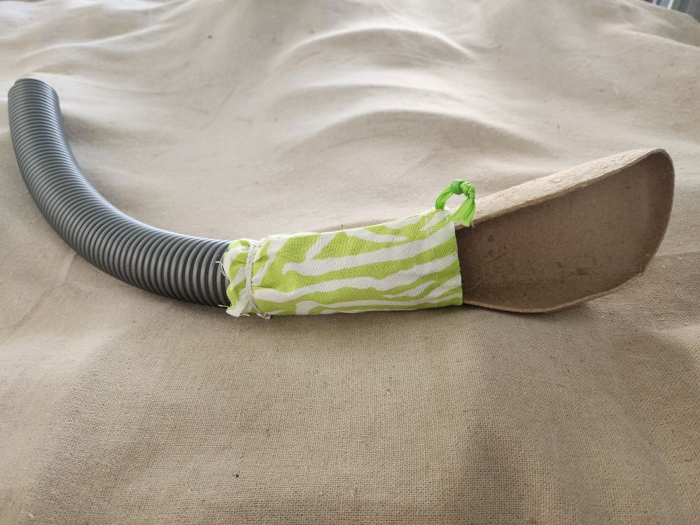 A lightweight insole taped to a vacuum cleaner hose with a pretty cotton grip
