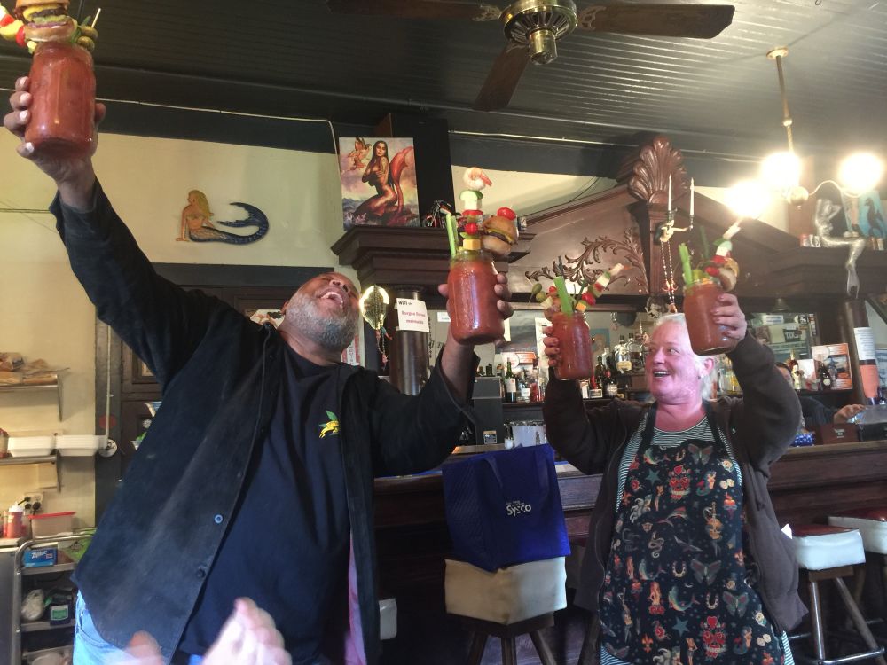 Two people serving the Ultimate Bloody Mary with enthusiasm at Burgee Dave’s at the Mayo.