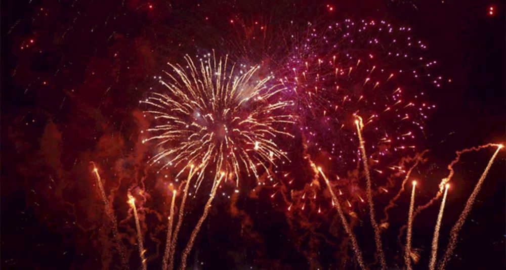 a fireworks display with purple and gold colored fireworks