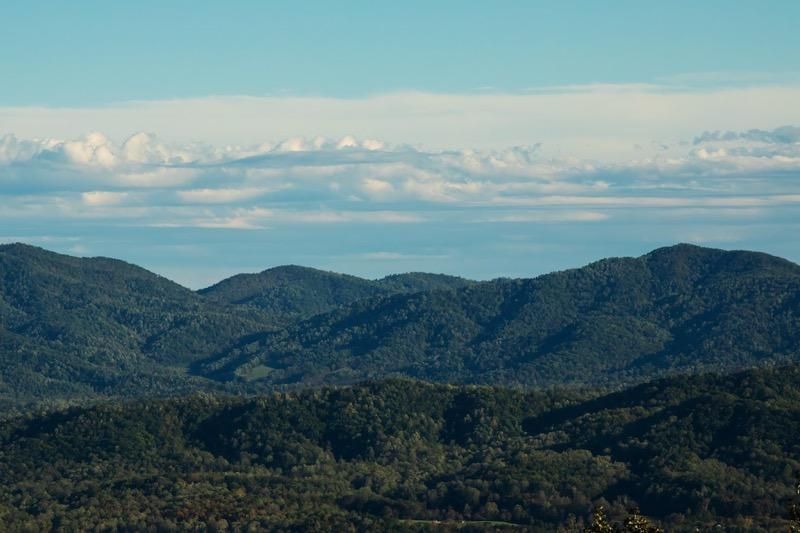 blue sky with a band of white clouds over the blue ridge mountains 