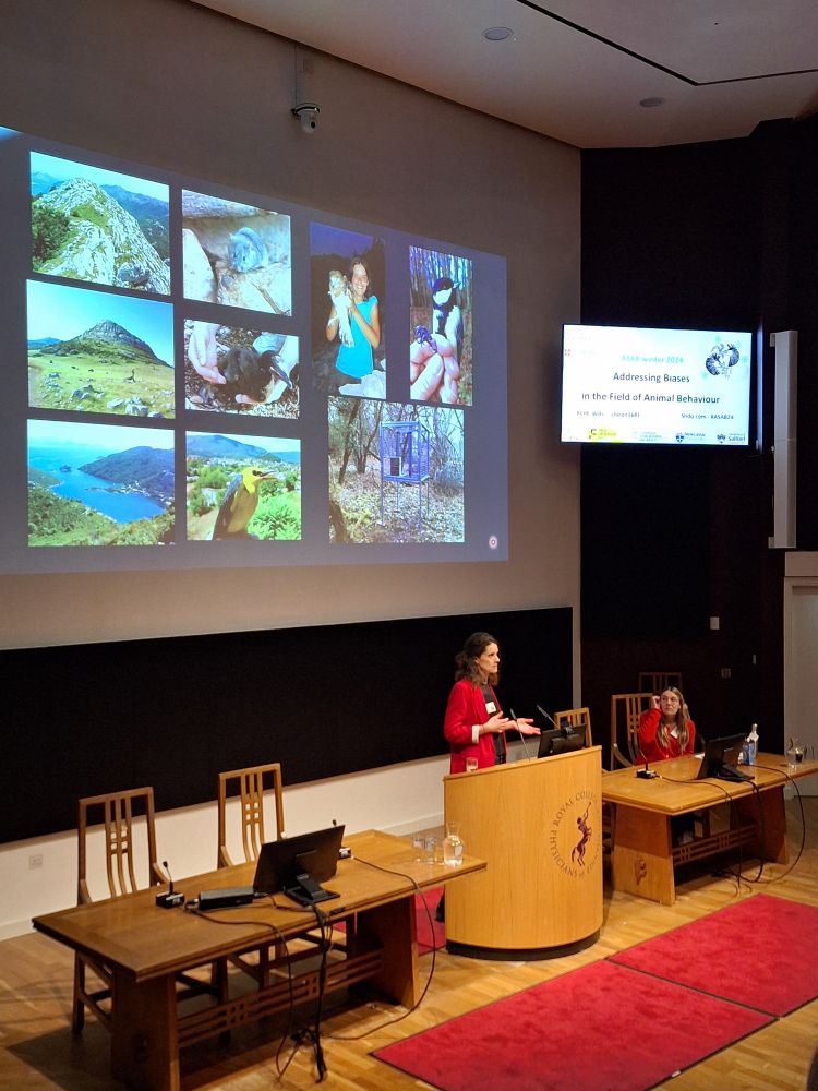 Antica stands in front of the lectern in the lecture theatre. On the screen is a number of photos from Antica's fieldwork. 
