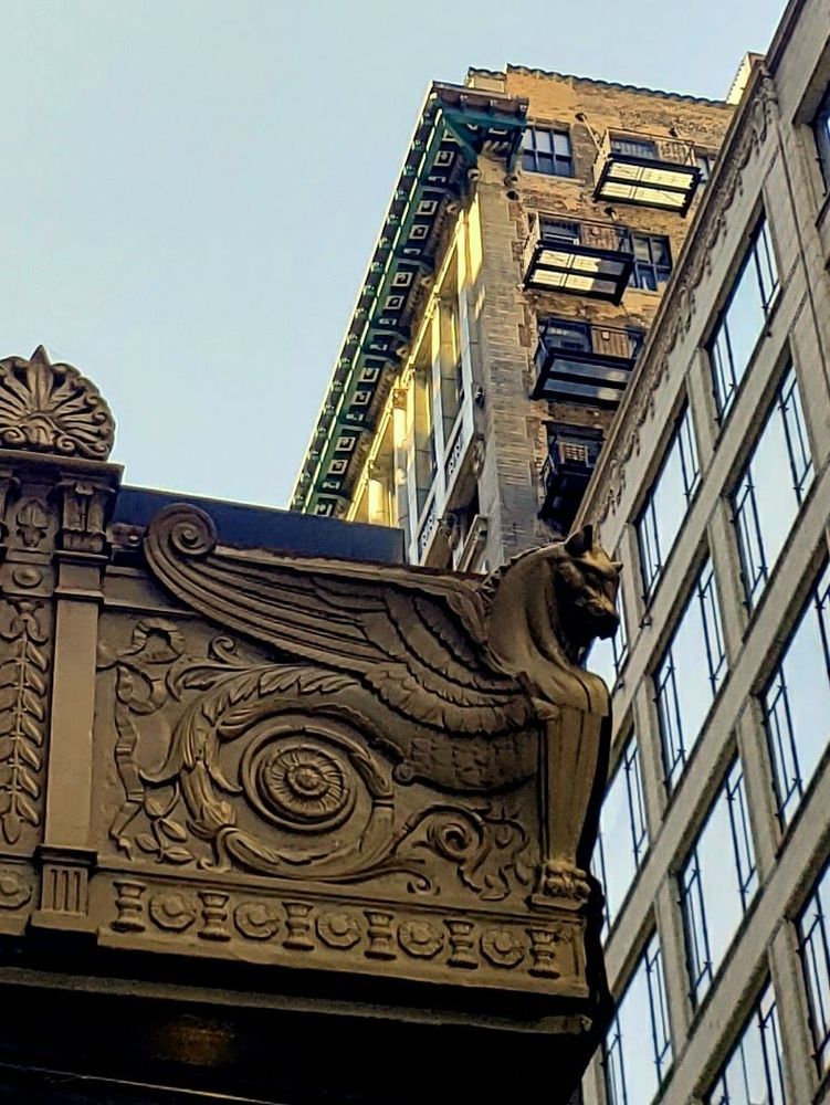 A golden Art Nouveau winged horse fish creature on the corner of a theater marquee in Chicago.