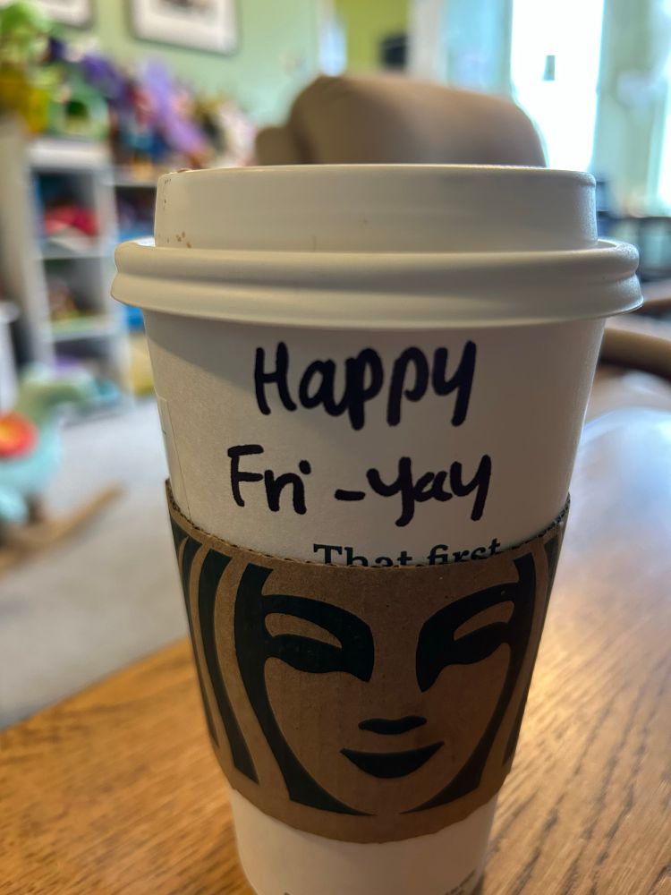 Starbucks cup with the writing “Happy Fri-yay” on it 
