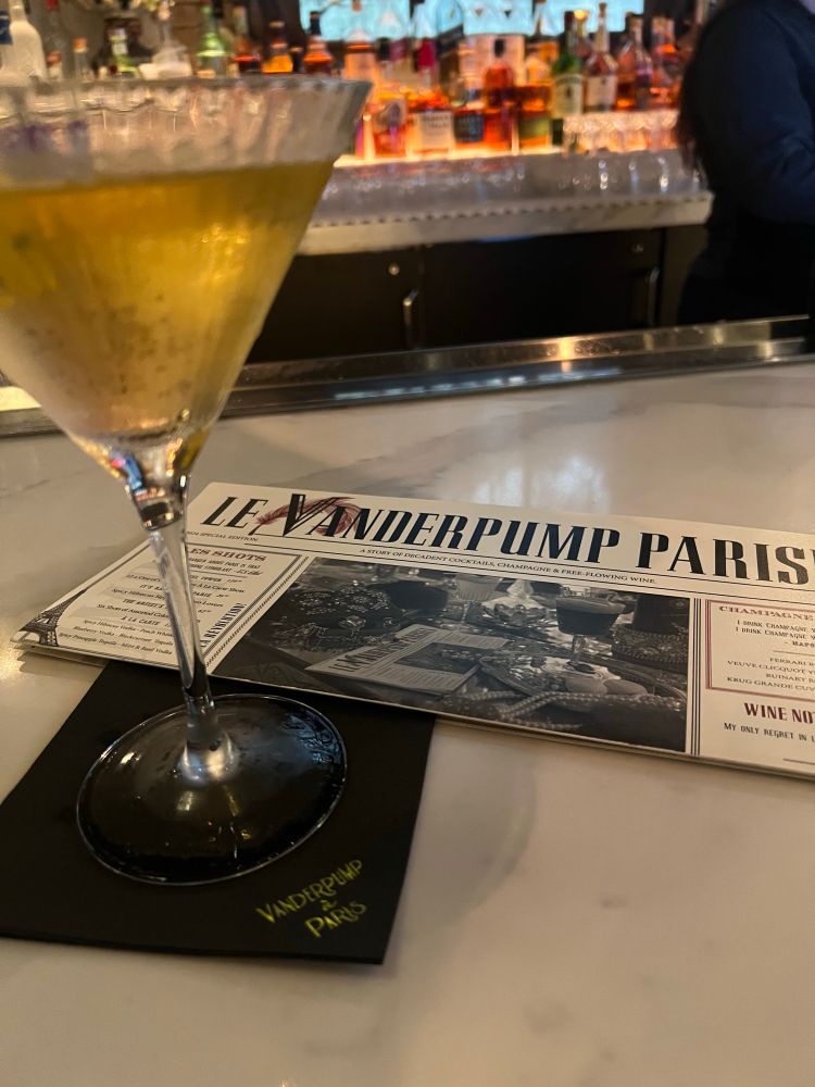 Photo of my martini with the Vanderpump a Paris menu on the bar 